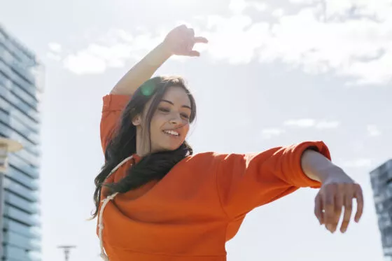 Young contemporary dancer wearing red hoodie shirt, practicing her passion