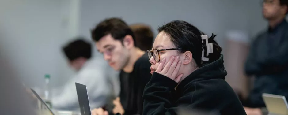Etudiante écoutant en cours et travaillant sur ordinateur