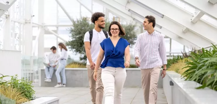 3 étudiants marchent sous la verriere du campus de l'essca à bordeaux