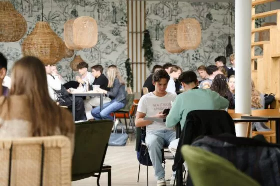 etudiants assis à des tables de la cafeteria du campus de l'ESSCA à angers