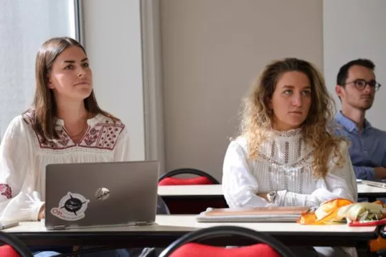 deux étudiantes écoutent un cours sur le campus d'Angers. un étudiant en fond