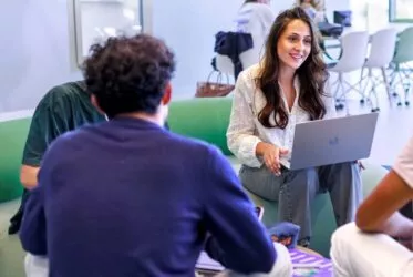 Jeune femme qui travaille sur un ordinateur dans une salle moderne