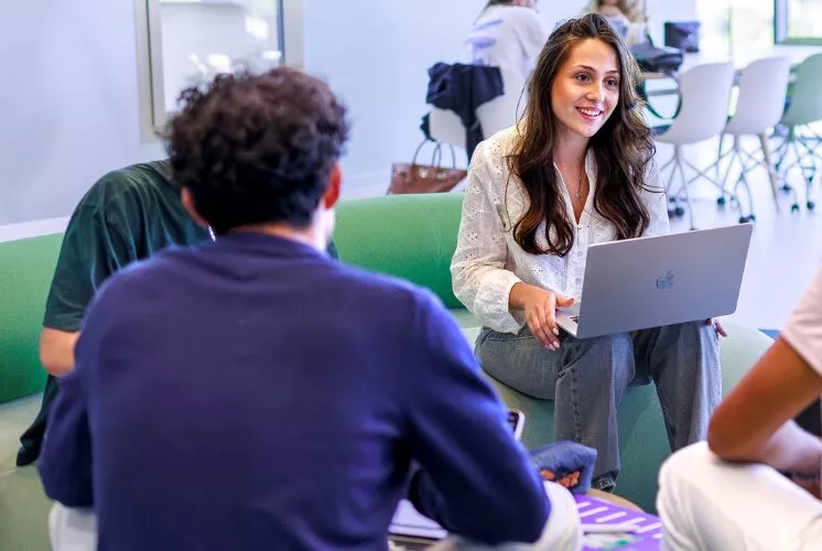 Jeune femme qui travaille sur un ordinateur dans une salle moderne