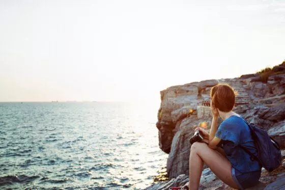 Jeune femme regardant la mer qui brille au soleil