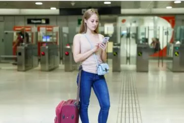 Jeune femme devant des portes de contrôle à l'aéroport