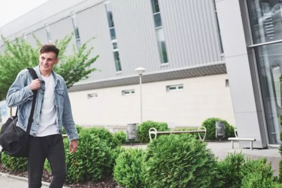 Jeune étudiant portant un sac à dos marche devant l'ESSCA