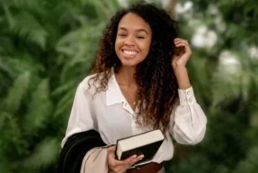 Jeune femme avec un livre se tient une mèche