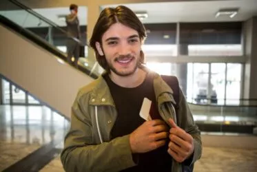 Jeune homme à l'aéroport en train de ranger son passeport