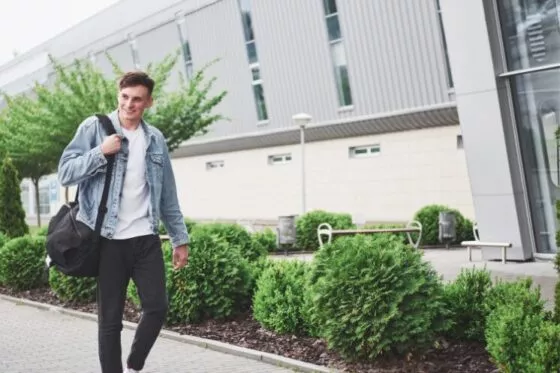 Jeune homme qui marche avec une sacoche